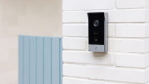 Frente del videoportero inteligente EZVIZ HP5 con cámara, lector RFID y timbre, instalado en una pared de ladrillo